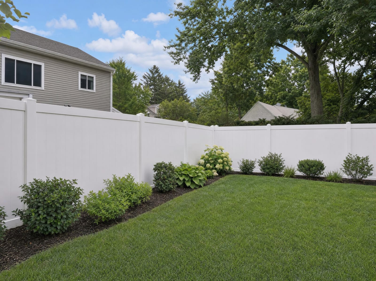 White vinyl privacy fence enclosing a suburban backyard